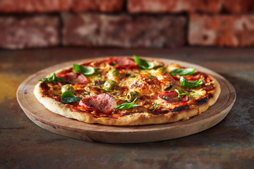 Thin crust pizza with ham, cheese and olive.  Freshly baked pizza (from wood-fired oven).  