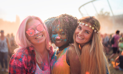 Multiethnic girls covered in colorful powder celebrating summer holi festival - obrazy, fototapety, plakaty