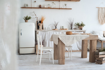 White textured kitchen in the style of shabby. A large textured table in the ecological style and...
