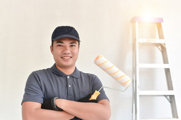 Asian Smiling painter holding a paint roller and backdrop has an aluminum ladder, Portrait of happy...