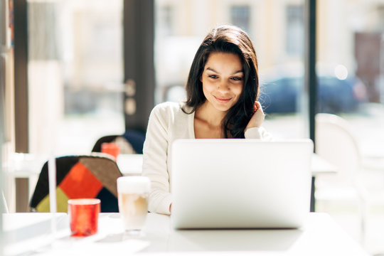 Brunette Using Laptop In Cafe