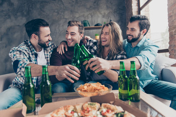 Stylish, bearded, successful guy said funny toast, his stylish friends with modern hairstyle looking at him and laughing, team of four persons clinking bottles with lager, having snacks on the table