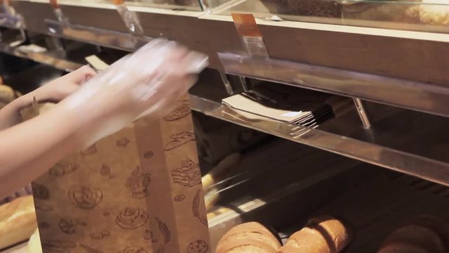 Hands lay bread in cardboard packaging
