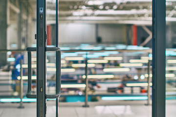 Open door in the modern office or shopping center in grey colors with bokeh background