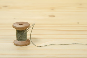 The old spool of thread with a needle.