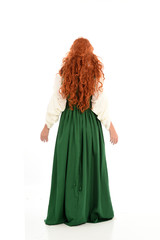 full length portrait of red haired girl wearing long green gown,. standing pose with back to the camera, isolated on white studio background.