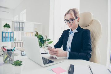 Apps gadget media cellular concept. Portrait of stylish trendy financier holding smart phone in hands typing sms using wifi 4G internet enjoying time out sitting in modern office with interior