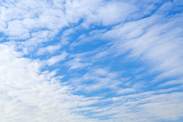 White feather clouds against a bright blue sky (background)