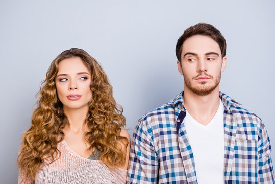 Conflict insult disagreement distrust fight cheat quarrel crisis concept. Portrait of modern couple in casual outfits looking at each other with eyes isolated on grey background