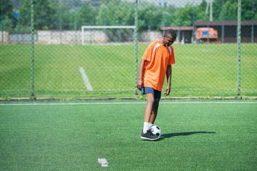 african american elderly man training with football ball in field