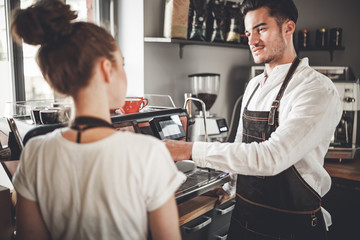 Successful cafe business, professional baristas team using coffee machine