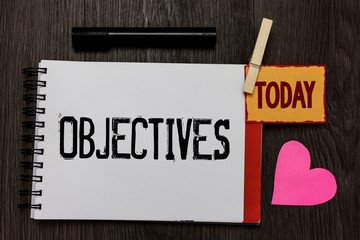 Word writing text Objectives. Business concept for Goals planned to be achieved Desired targets Company missions Work register notebook clipped remember card love heart table background.