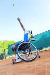 Foto op Canvas disabled tennis player hits the ball for service © Marino Bocelli