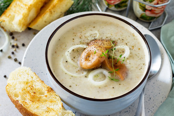 Puree soup mushrooms with croutons in a bowl close-up on a light slate background. Diet menu. The concept of healthy eating.