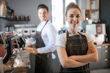 Successful business owner, professional baristas standing at the bar counter in cafe
