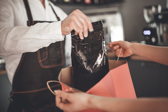 Professional Barista Giving Coffee Pack Into Shopping Bag For Customer At Cafe