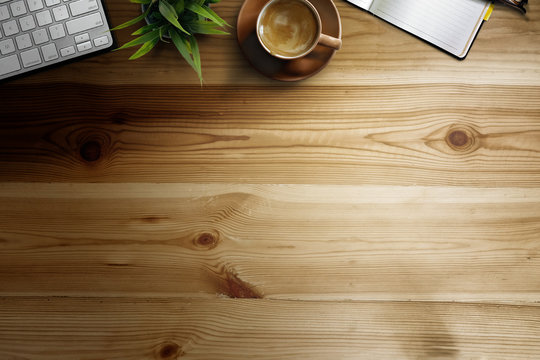 Office wooden desk with computer, coffee cup and plant. Business workspace and copy space.