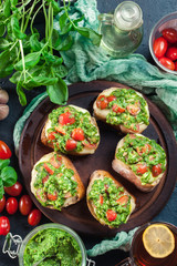 Bruschetta with fresh pesto, mozzarella and cherry tomatoes on cutting board