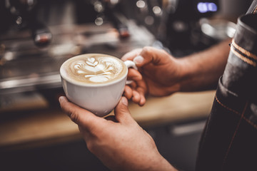 Fototapeta na wymiar Latte art, professional barista presenting cup of coffee