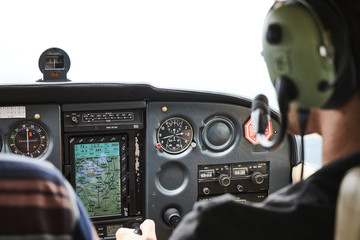 Closeup of a cockpit of cessna skyhawk 172 airplane with two pilots.