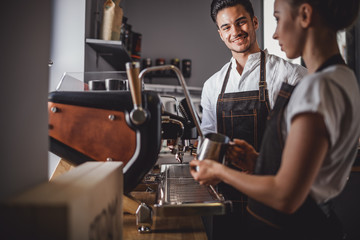 Fototapeta na wymiar Coffee business, baristas team making coffee using machine at cafe