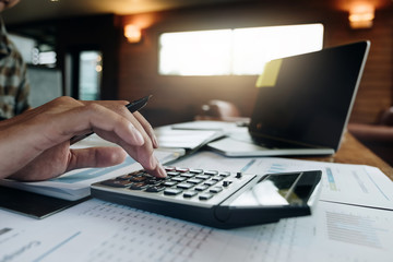 businessman working with calculator for financial document in office. male accountant doing accounting and calculating. bookkeeper making calculation. Savings, finance