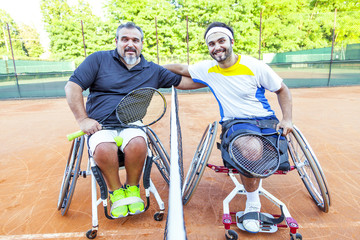 pair of disabled tennis players hugging each other under the net