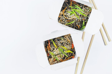 .Two paper boxes with Asian noodles on a white background.