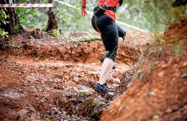 Extreme cross country runner moving through rocky road in mountains