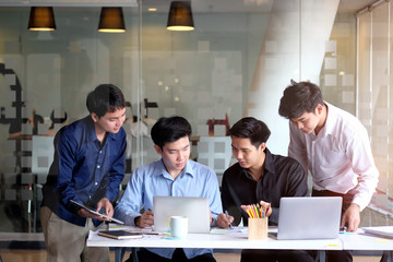 Group of coworkers discussing documents in a meeting at office.