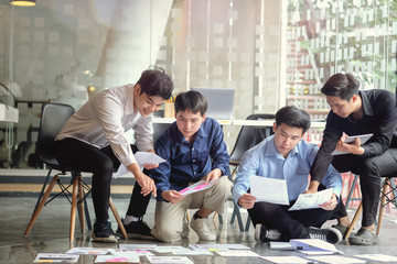 Fototapeta premium Team of worker collaborating and sitting on the floor in a office.