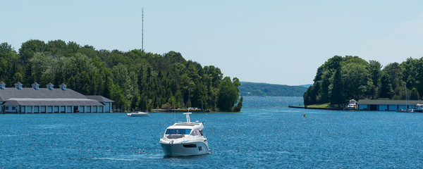 White power boat and boathouses on Lake Charlevoix in Upper Michigan
