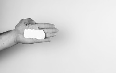 small white piece of paper in his hand man monochrome