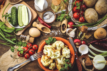 fried cauliflower in batter. vegetables and spices. wooden background.