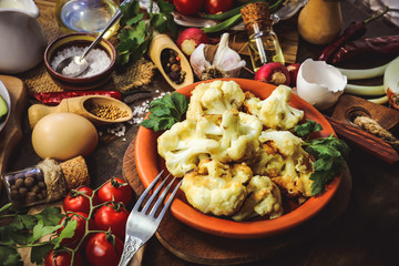 fried cauliflower in batter. vegetables and spices. wooden background.