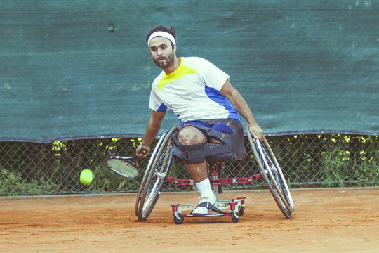 disabled tennis player hits the ball forehand