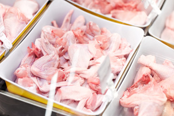 sale and food concept - poultry meat in bowls at grocery stall
