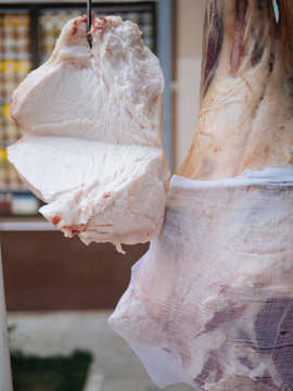 Piece of cut lard hangs on hook