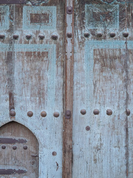 Aged wooden door in metal rivets