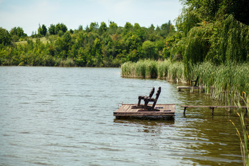 a wooden pier on a lake with a fishing chair