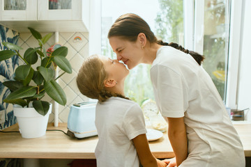 The happy smiling caucasian family in the kitchen preparing breakfast