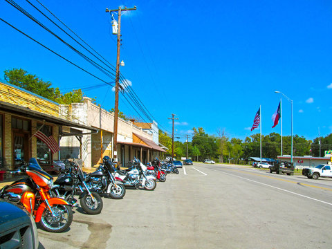 Fototapeta Parking motorcycles in a row along the street.  Motorbikes of bikers parked at the usual meeting place near Canton in Texas on a sunny day during a weekend trip. 