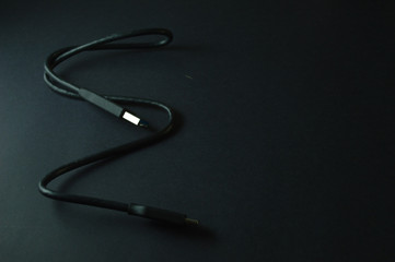 Cabo USB solto em ondas isolado em fundo preto