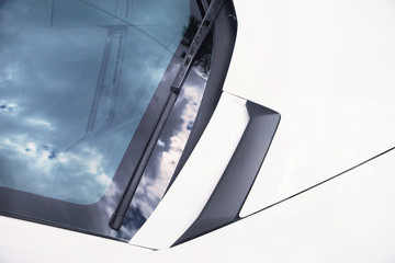 windscreen with windshield wipers and a white car bonnet
 