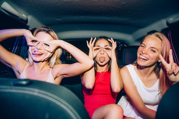A picture of funny girls making funny figures aroung their eyes. They are showing uo their tongues....