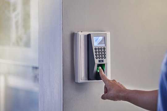 Yong man or woman push finger down on the electronic control machine to access the door. Selective focus