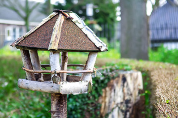 Bird feeder made in a form of a house in a park
