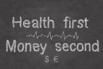Obraz premium Your health is first, money are second sign on the chalk board