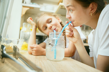 The happy smiling caucasian family in the kitchen preparing breakfast