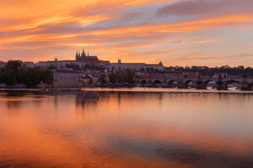 Fototapeta premium The View on Prague gothic Castle with Charles Bridge after the sunset, Czech Republic - Beautiful reflections of Vltava river